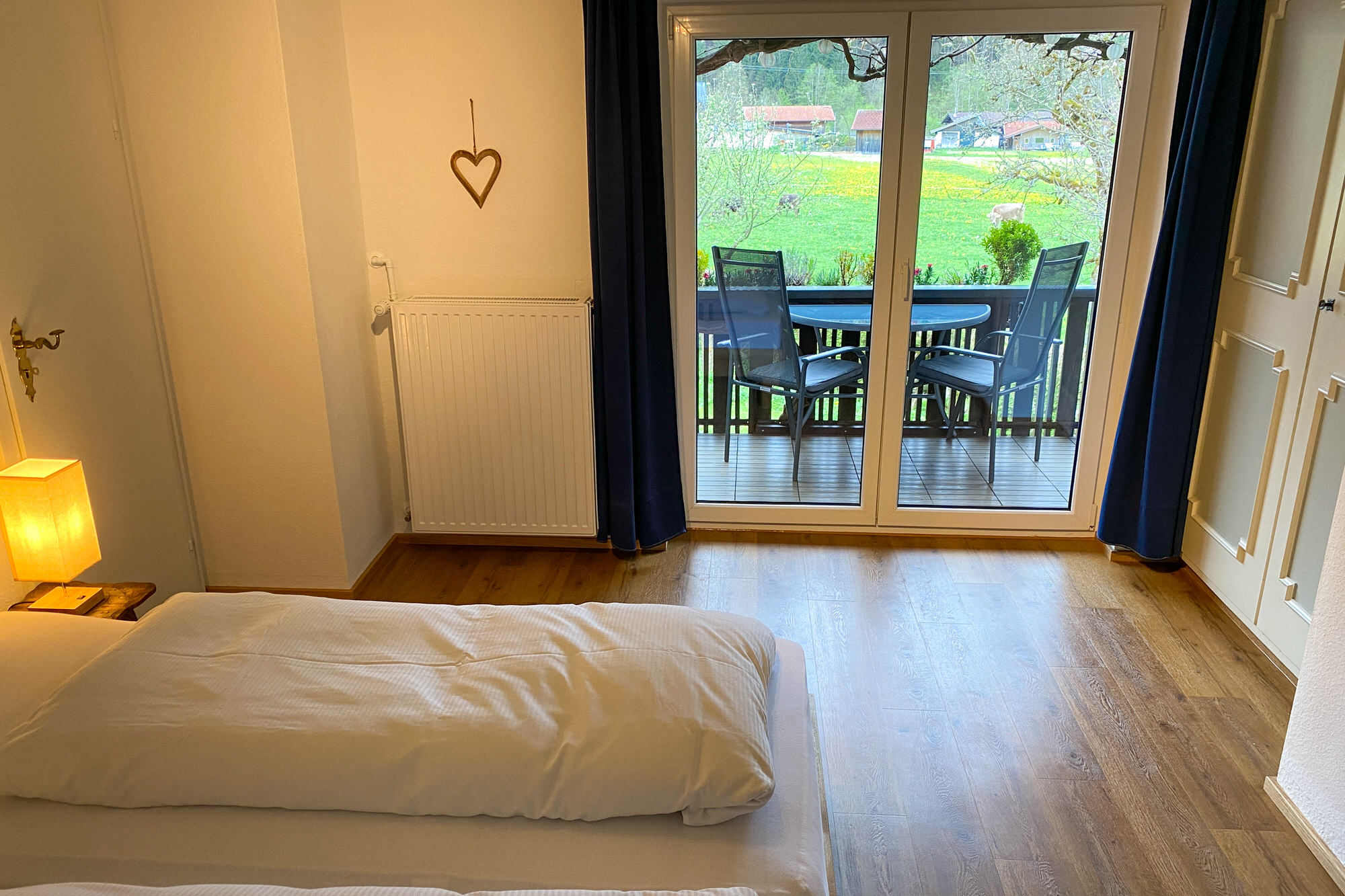 Schlafzimmer mit Zugang zum Balkon und Blick ins Grüne.