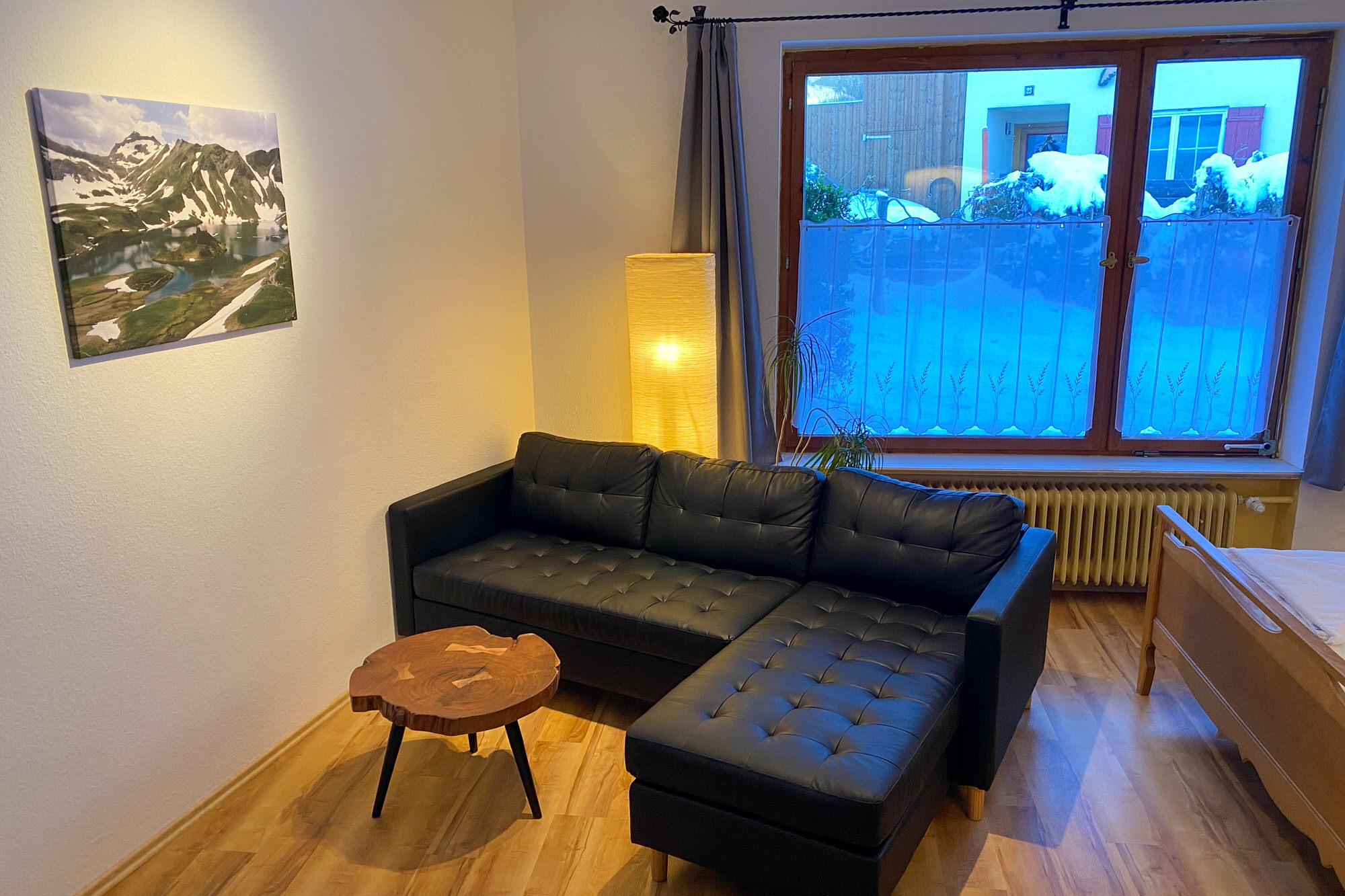 Wohnbereich mit Sofa und Panoramafenster in der Ferienwohnung im Allgäu