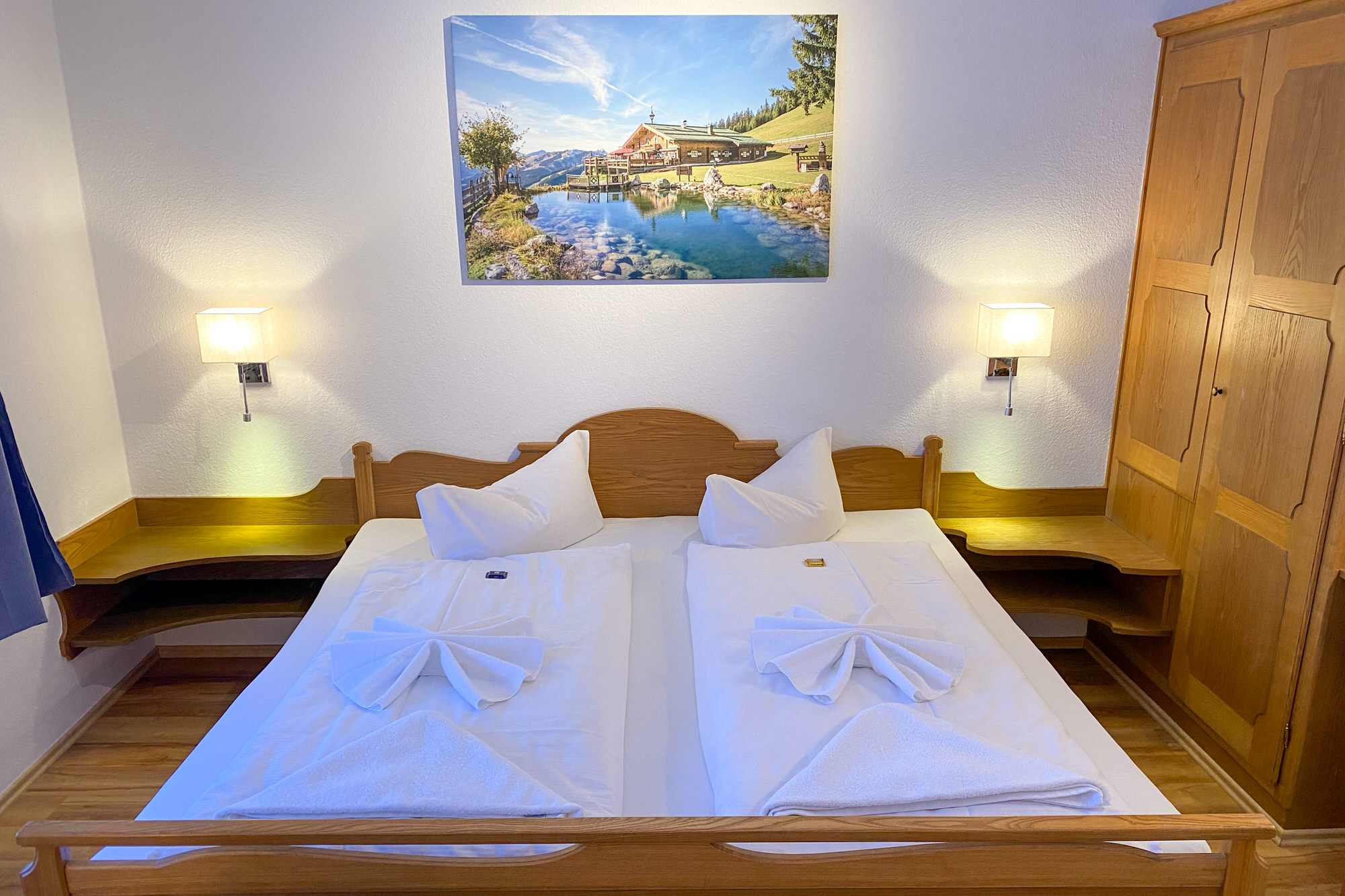 Schlafzimmer mit gemütlichem Doppelbett und großem Naturbild