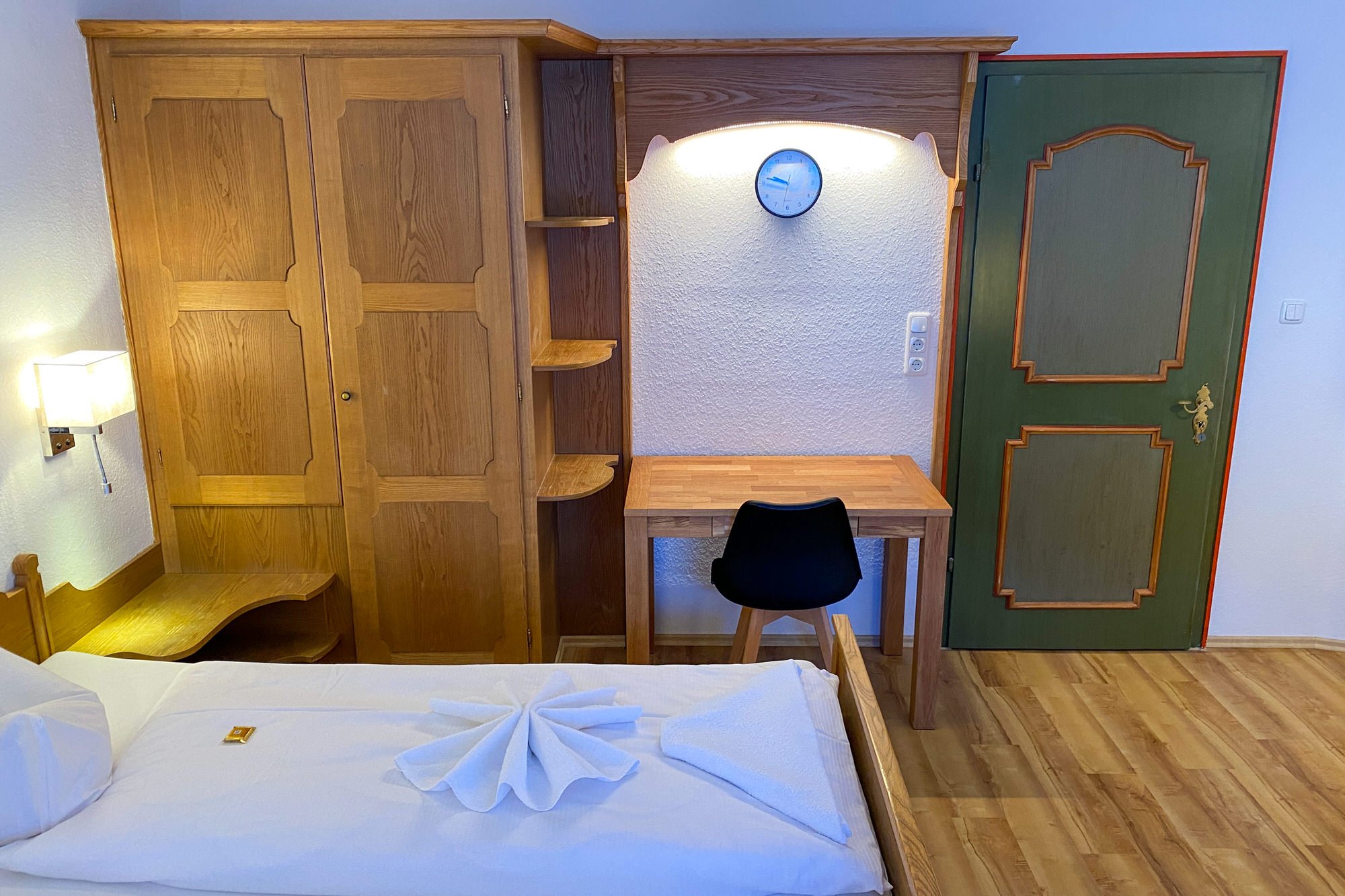 Schreibtisch und Holzschrank im Schlafzimmer der Ferienwohnung