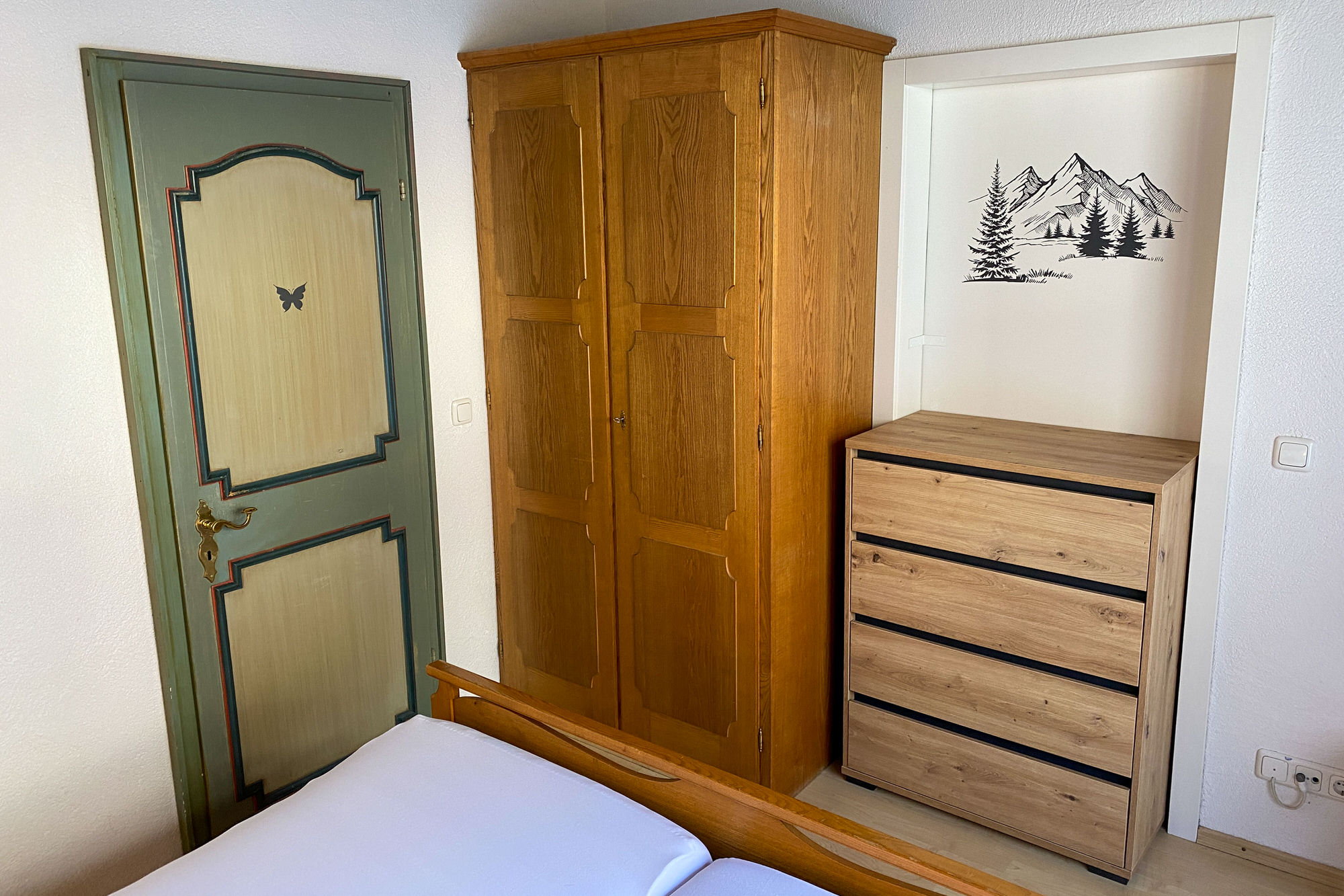Kommode und Schrank im Schlafzimmer mit alpinem Wandmotiv