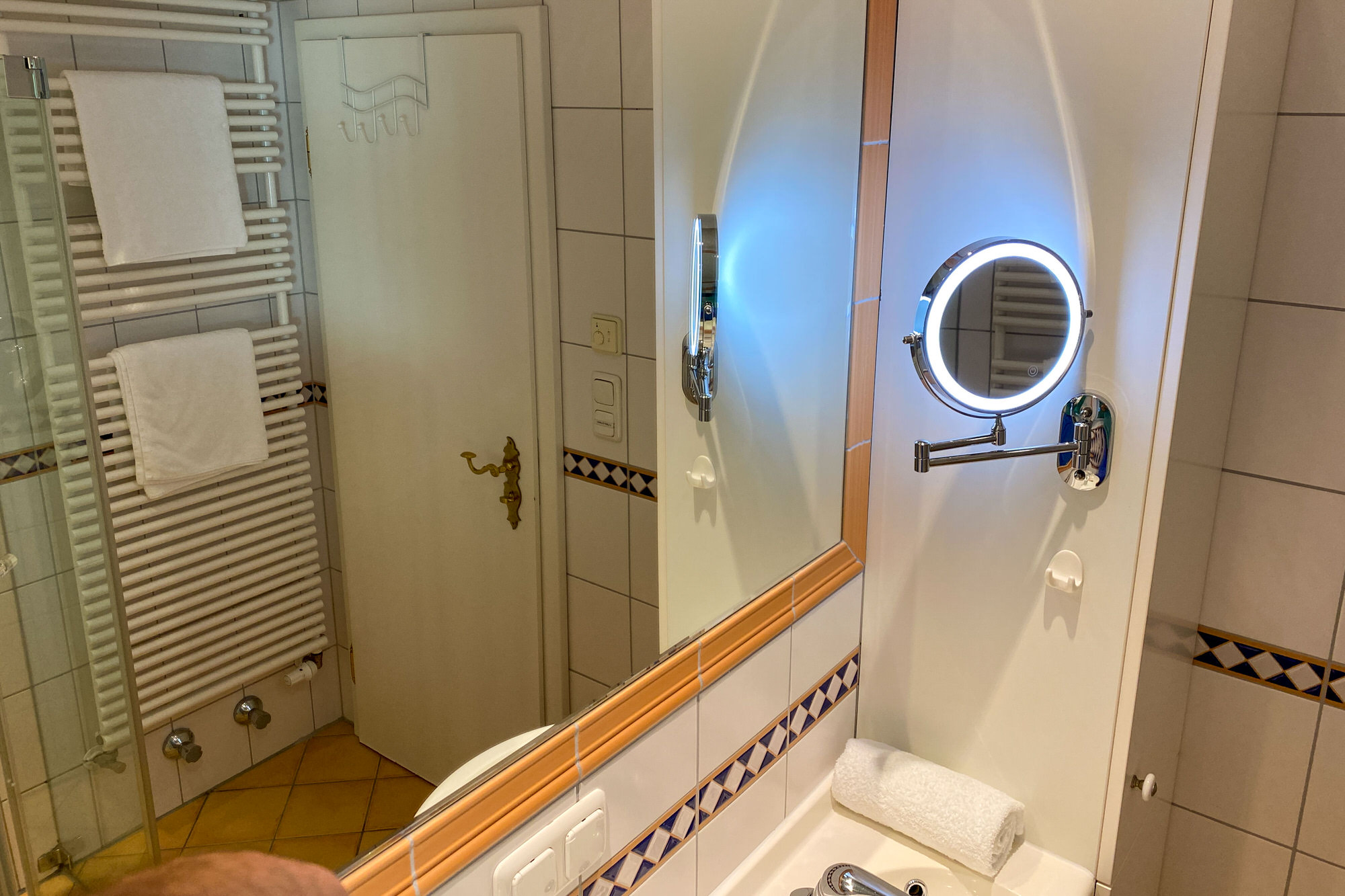 Badezimmer mit beleuchtetem Spiegel und Handtüchern