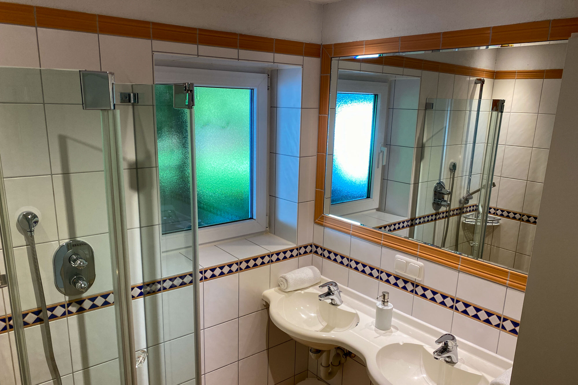 Dusche und Doppelwaschbecken im Bad der Ferienwohnung