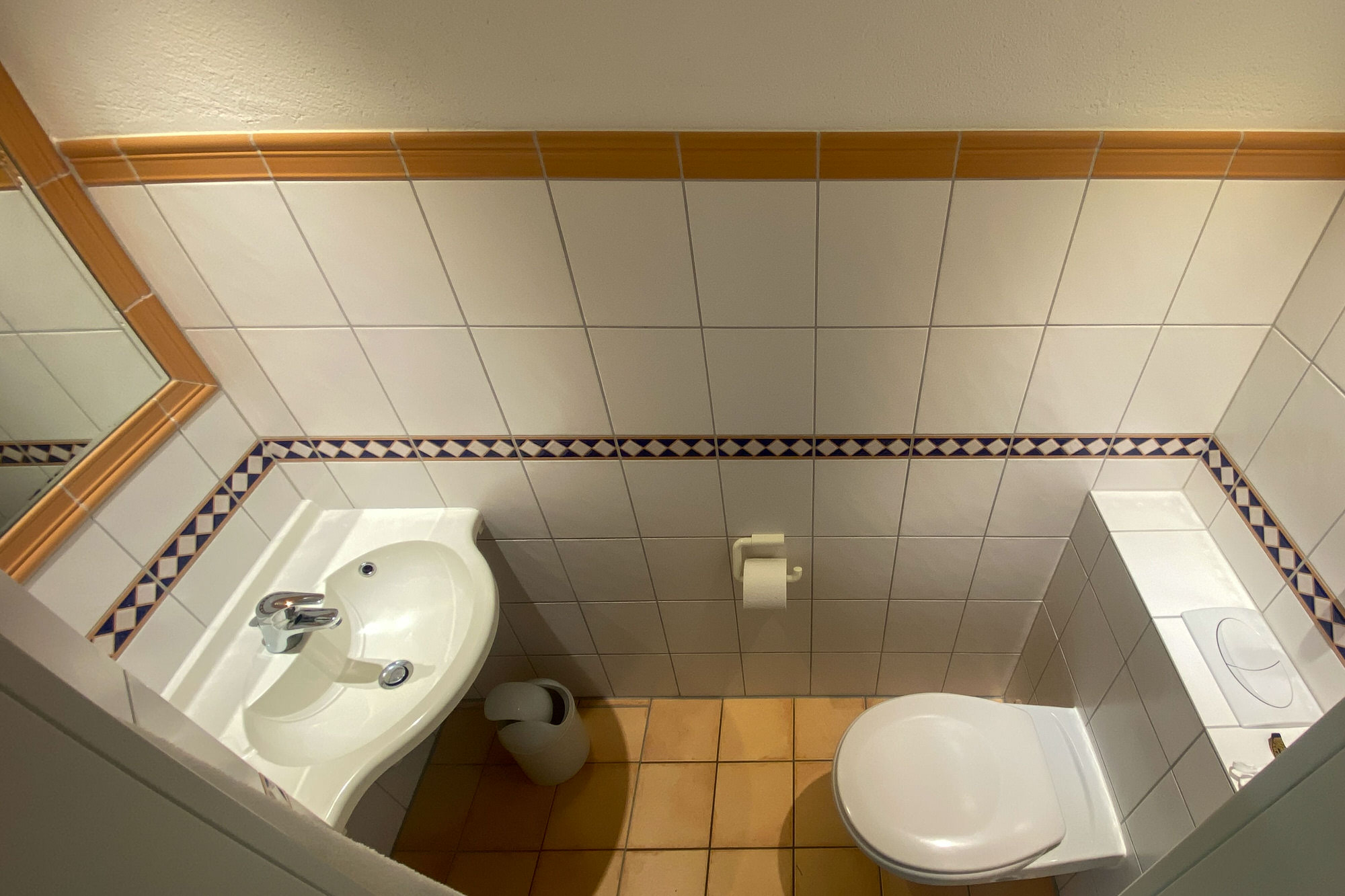 Gäste-WC mit Waschbecken und Wandfliesen