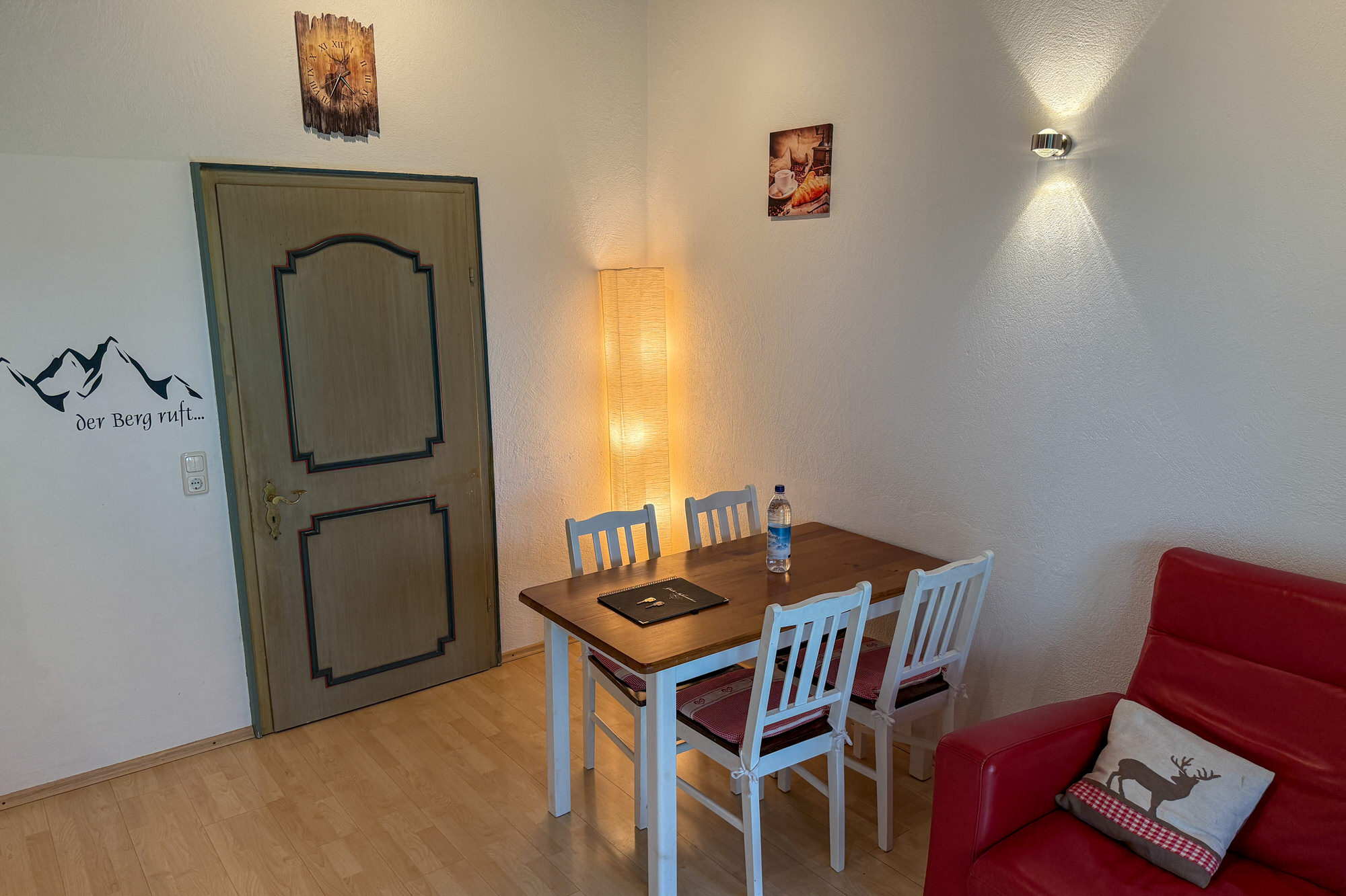Essbereich mit Holztisch und Wanddeko in der Ferienwohnung im Allgäu